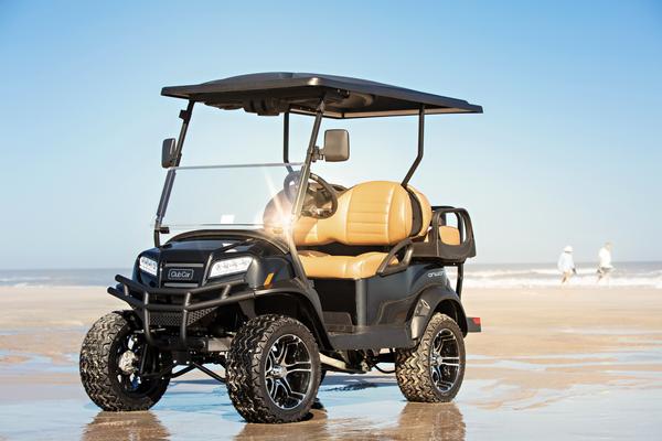 Ein Golfcart Onward von Club Car in der Lifted Version steht auf einem Strand.