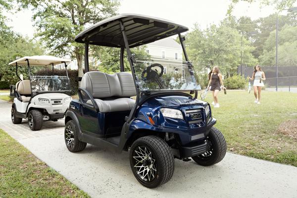 Golf buggy Onward from Club Car parked in front of a hotel complex.