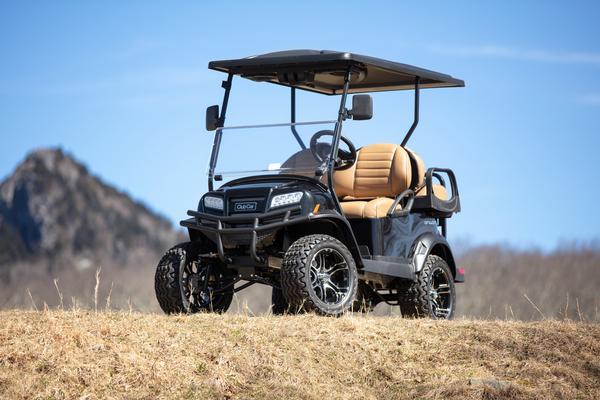 Ein Onward-Golfbuggy von Club Car in der Lifted-Version ist auf offenem Gelände geparkt.