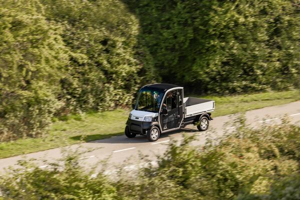Elektro Transporter URBAN von Club Car bei der Fahrt auf einer Landstraße.
