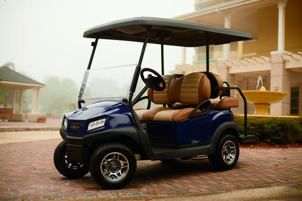 Golfcart Tempo 2+2 von Club Car steht vor einem Gebäude.