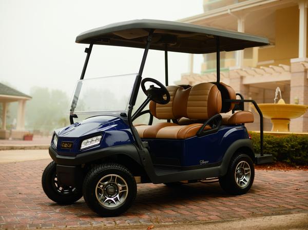 Golfcart Tempo 2+2 von Club Car steht vor einem Gebäude.